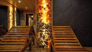 A spa area with wooden loungers and a stone pillar with embedded lighting.
