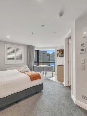 Een moderne hotelkamer met een groot bed, een zithoek en uitzicht op de omgeving.