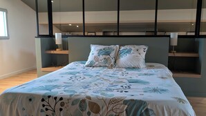A bedroom with a bed, pillows, a headboard, and built-in shelving. - Cozy 2-room apartment with a whirlpool tub (Vaugneray)