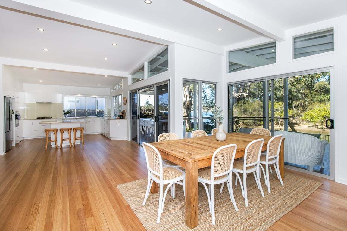Una cocina amplia con comedor, ventanas grandes y vistas al exterior.