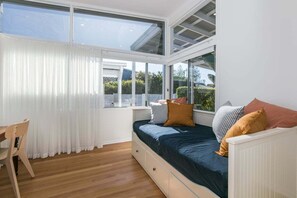 A bedroom with a bed, a window, a chair, and a desk. - Luxury Waterfront Stay at Tallebudgera Creek (Gold Coast)