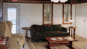 Una sala de estar amoblada con sofá, sillón y mesa de centro.