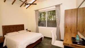 A bedroom with a bed, a desk, a chair, a window with curtains, and a ceiling fan.