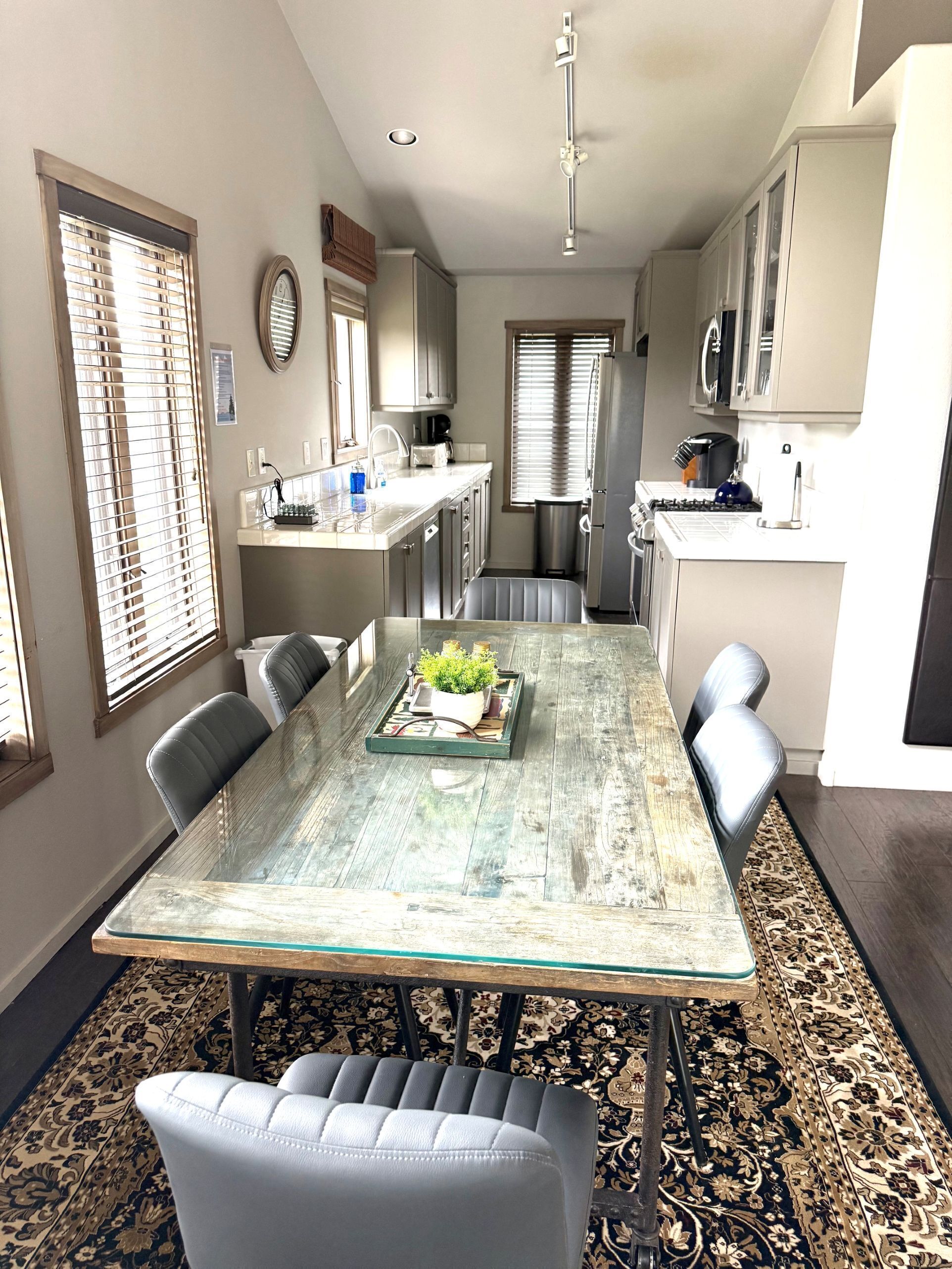 Un coin repas avec une table en verre, des chaises et un plateau décoratif.