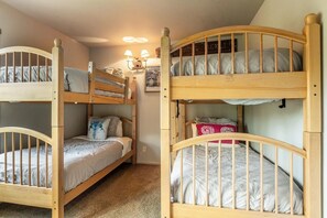 Ein Zimmer mit zwei Etagenbetten, einer Wandleuchte und einem gerahmten Bild.