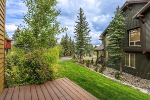 Il s’agit d’une propriété résidentielle dotée d’une terrasse, d’une pelouse bien entretenue et d’une maison à l’extérieur sombre.