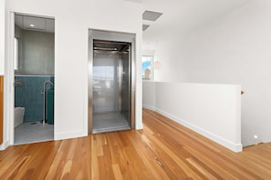 Ein modernes Interieur mit Holzboden, einer Glaseinschiebetür und Blick ins Freie.