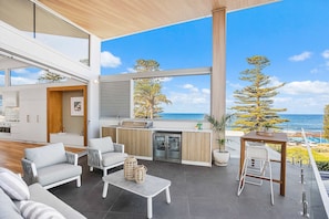 Ein moderner Wohnraum mit Küche, einer Sitzecke und Blick aufs Meer.