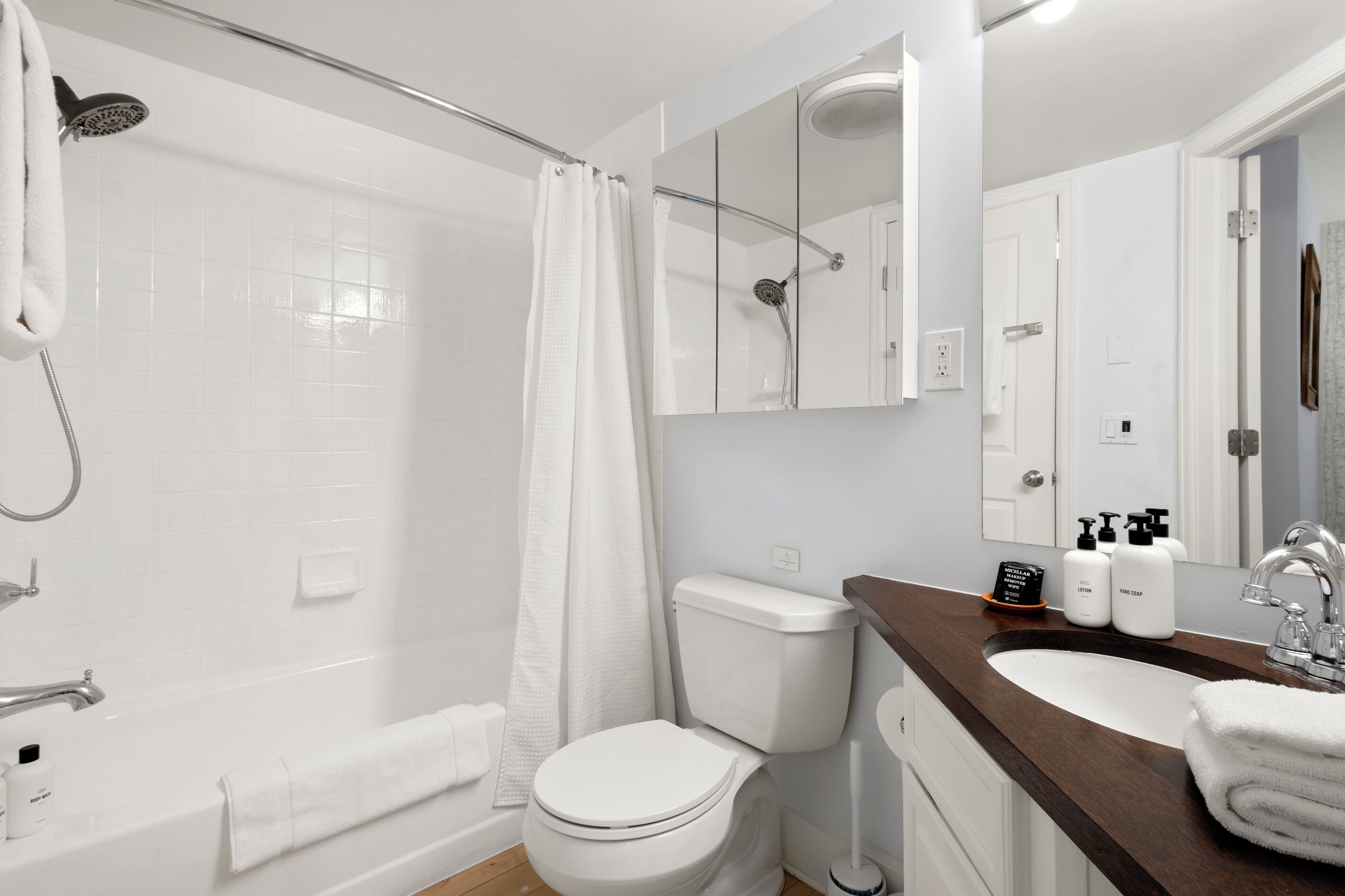 Une salle de bain moderne équipée d’une douche, de toilettes, d’un lavabo et d’un miroir.