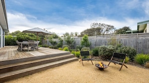 A wooden deck with outdoor furniture, a fire pit, and a garden with various plants. - Koonya Blairgowrie Luxe Retreat | Pet Friendly, Walk to Beach (Blairgowrie)