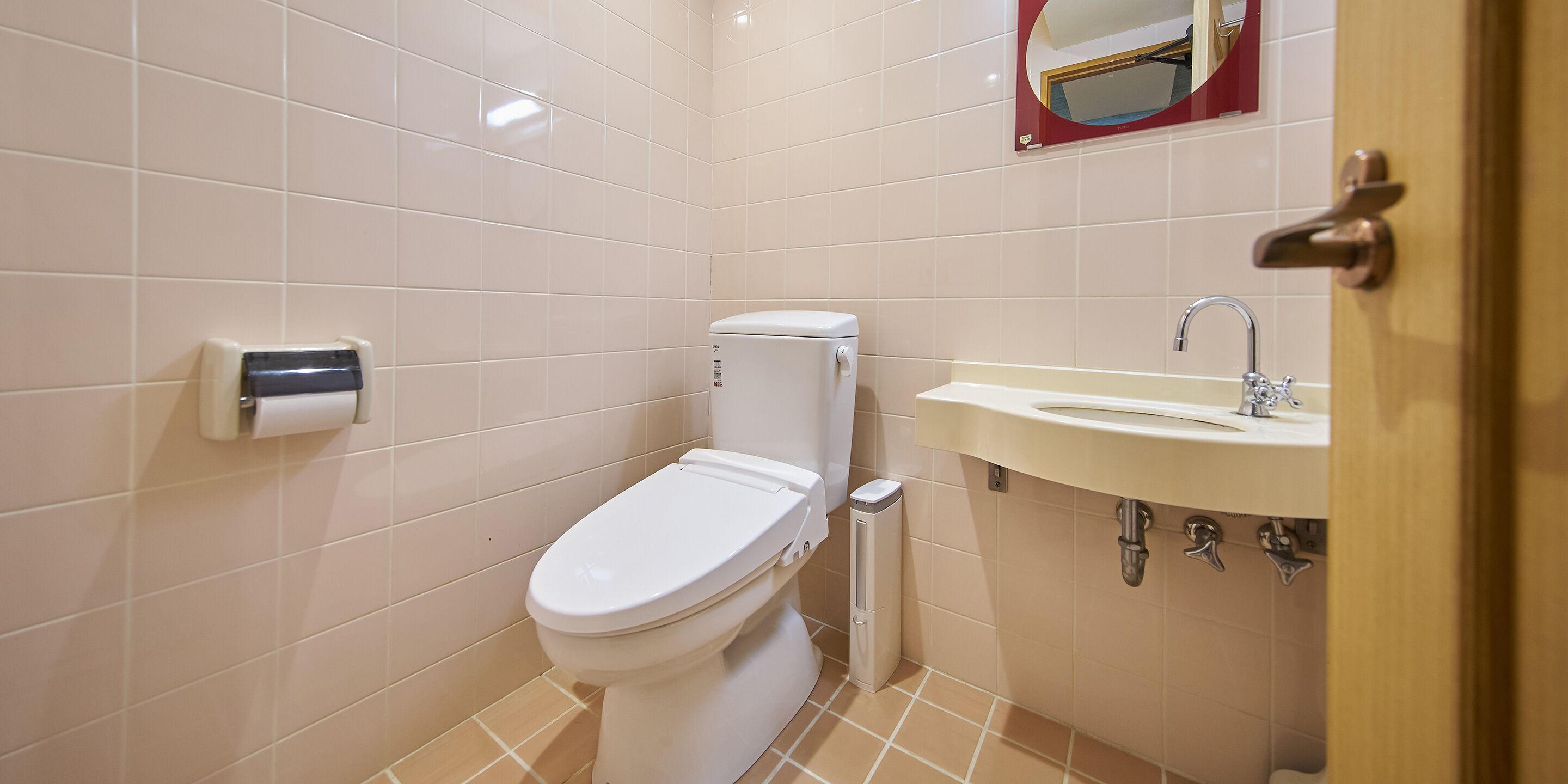 A bathroom with a toilet, a sink, and a hand dryer.