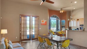 A dining area with a table, chairs, and a ceiling fan.