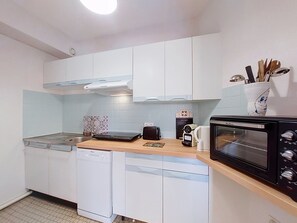A compact kitchen with white cabinets, a toaster, a coffee maker, and a microwave. - La Frégate by Interhome (Vaux Sur Mer)
