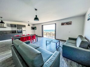 Een moderne woonruimte met keuken, eethoek en zithoek.