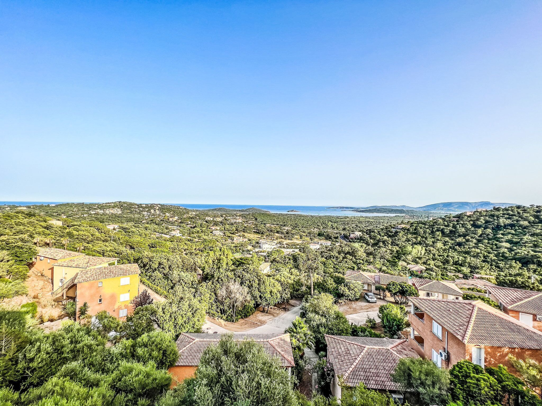 Zona residencial con casas rodeadas de vegetación y una vista despejada de la costa.