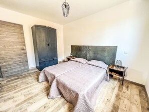 Ein Schlafzimmer mit einem Bett, einem Holzschrank und einer Pendelleuchte.