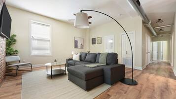 A modern living room with a sectional sofa, a coffee table, and a floor lamp.