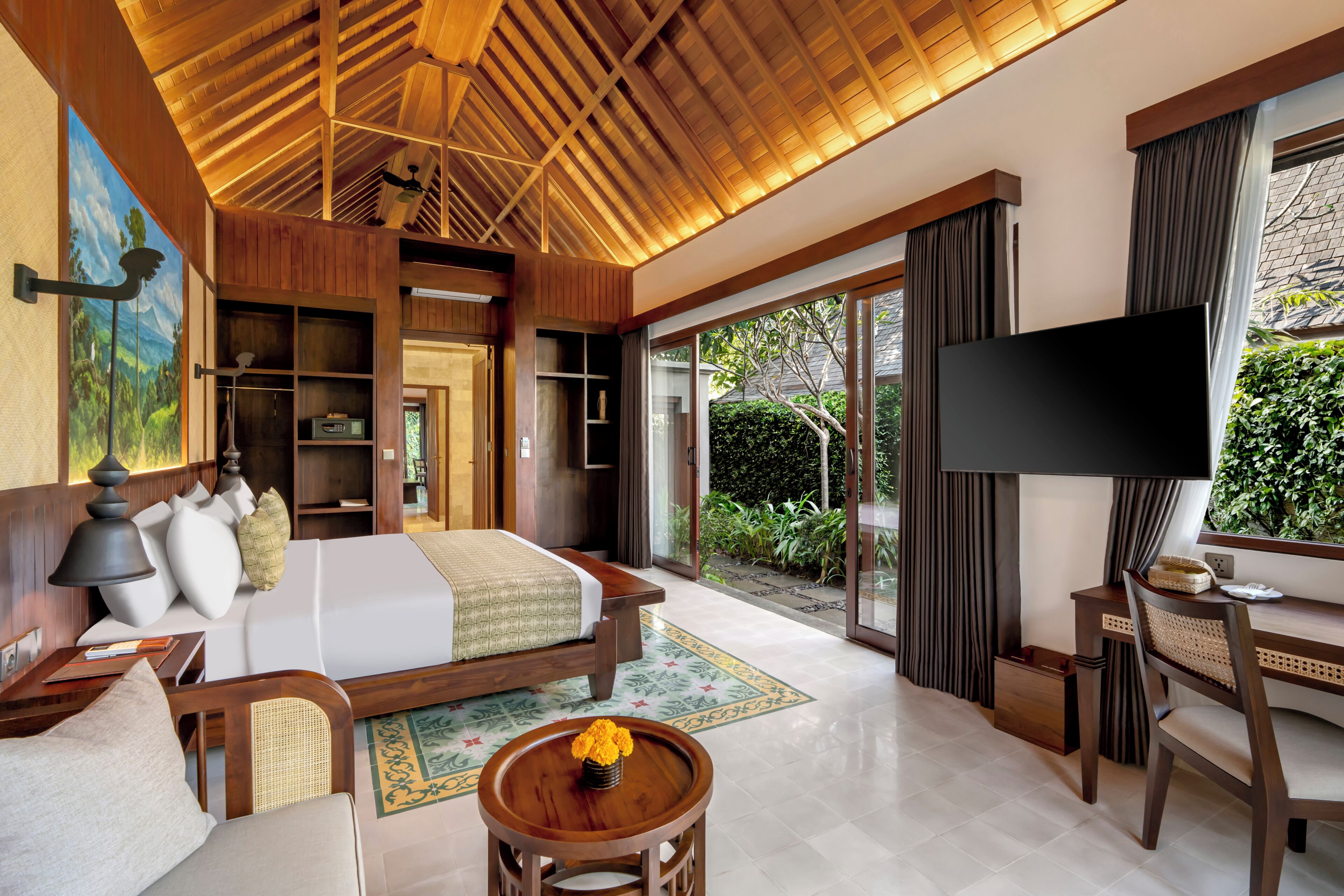 Una habitación de hotel con cama, televisión, escritorio y vistas al exterior.