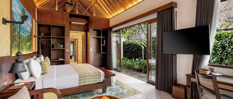 Una habitación de hotel con cama, televisión, escritorio y vistas al exterior.