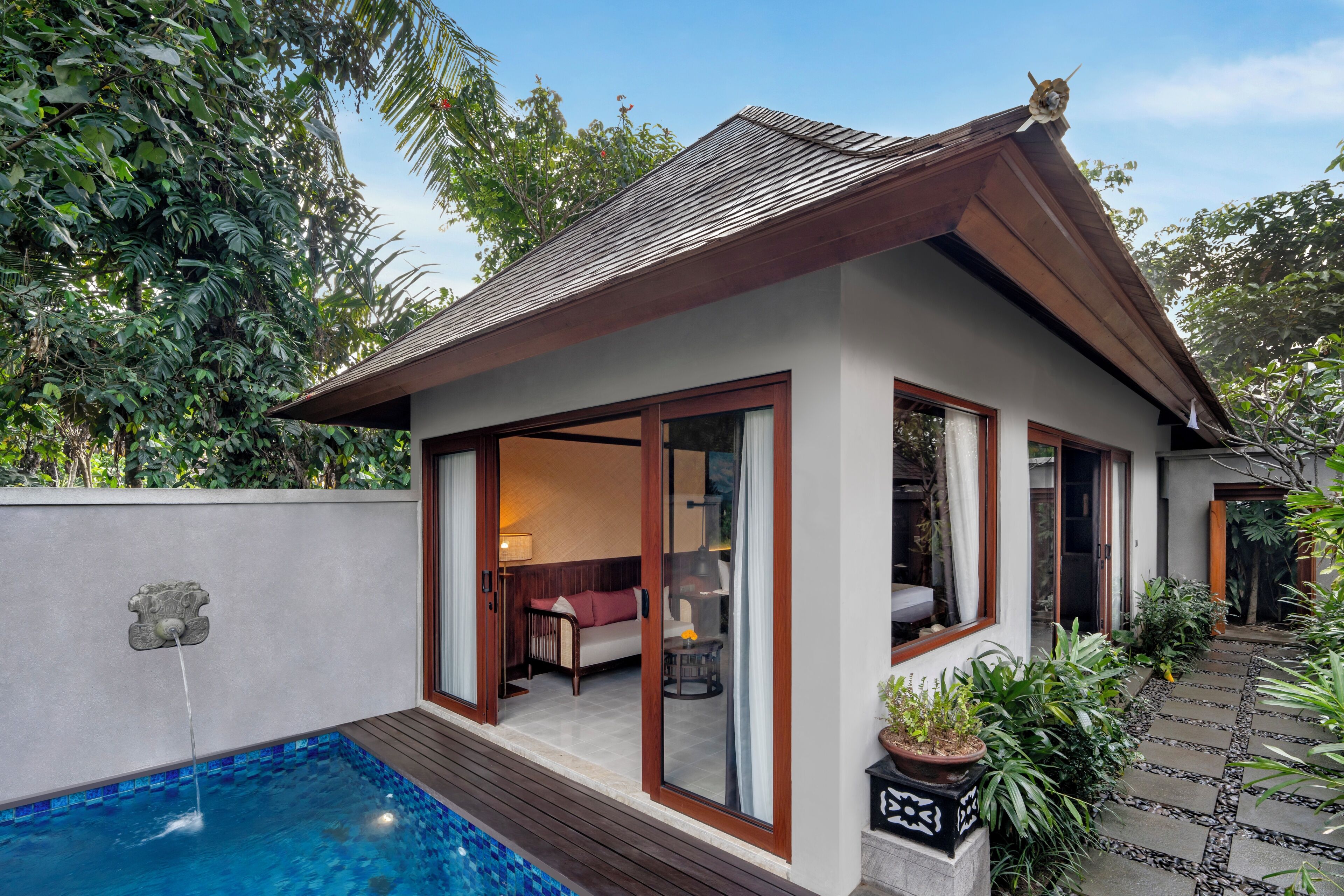 A house with a swimming pool, a covered patio, and a garden.
