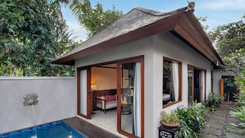 A house with a swimming pool, a covered patio, and a garden.