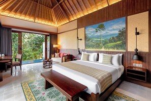 Quarto de hotel com uma cama grande, uma escrivaninha, uma cadeira, um banco e um quadro de uma paisagem.