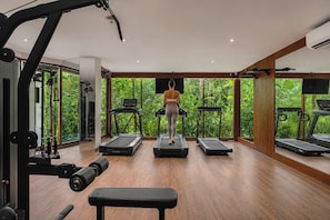 Un gimnasio con cintas de correr, una banca y equipo de ejercicio.