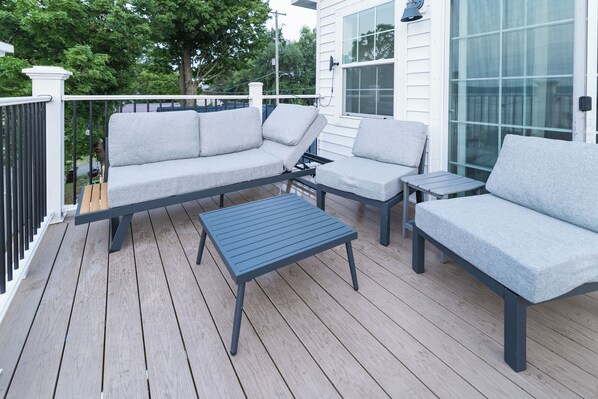 A deck with a sofa, two chairs, and a small table.
