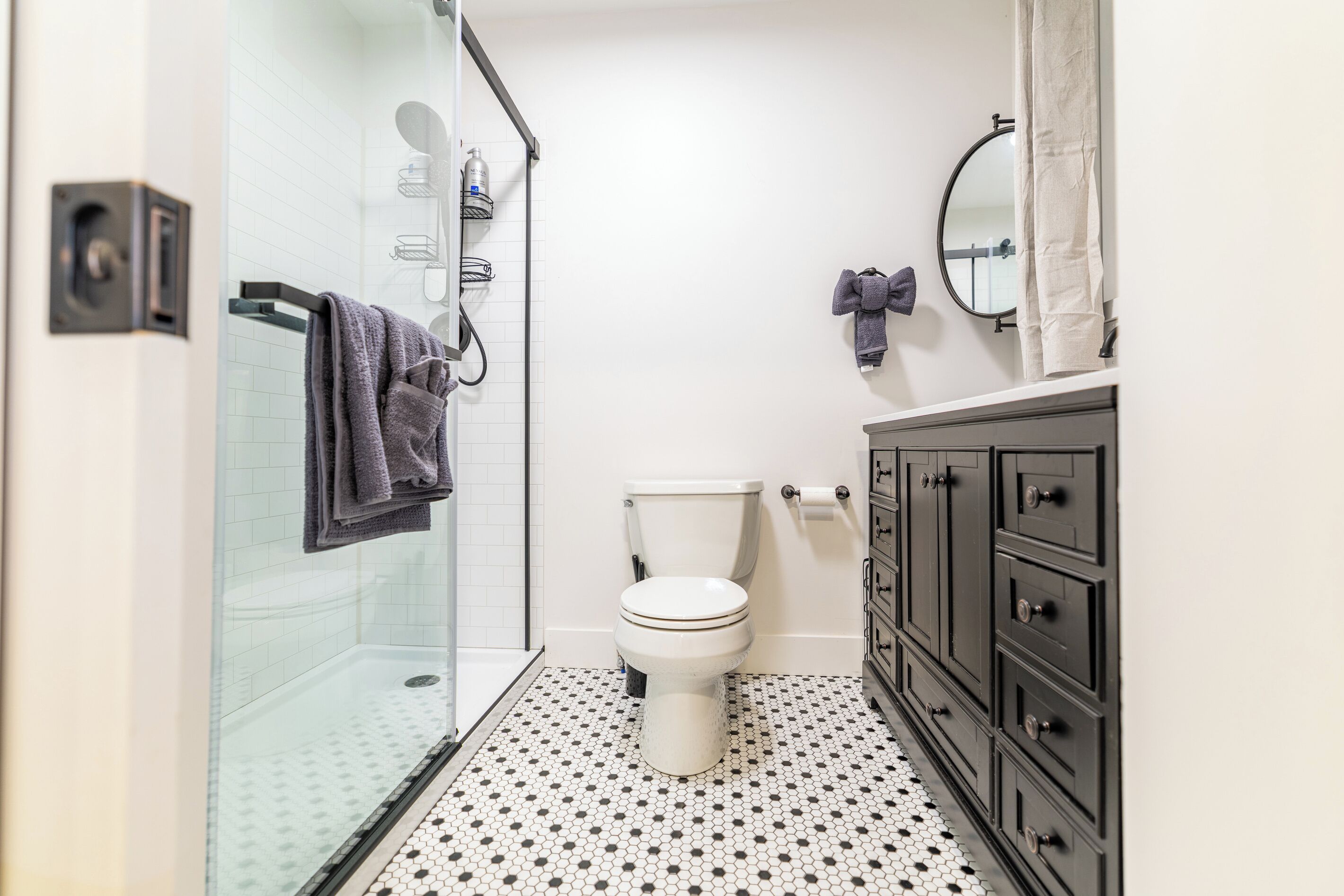 Une salle de bain comprenant des toilettes, une douche et un meuble-lavabo avec des tiroirs.