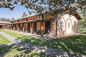 A building with a covered patio area, outdoor seating, and a small garden. - Casa Tera A: A graceful two-story apartment in the characteristic style of the Tuscan countryside, with Free WI-FI. (Grosseto)