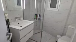 Ein Badezimmer mit weißem Waschbecken, Spiegel und Toilette.