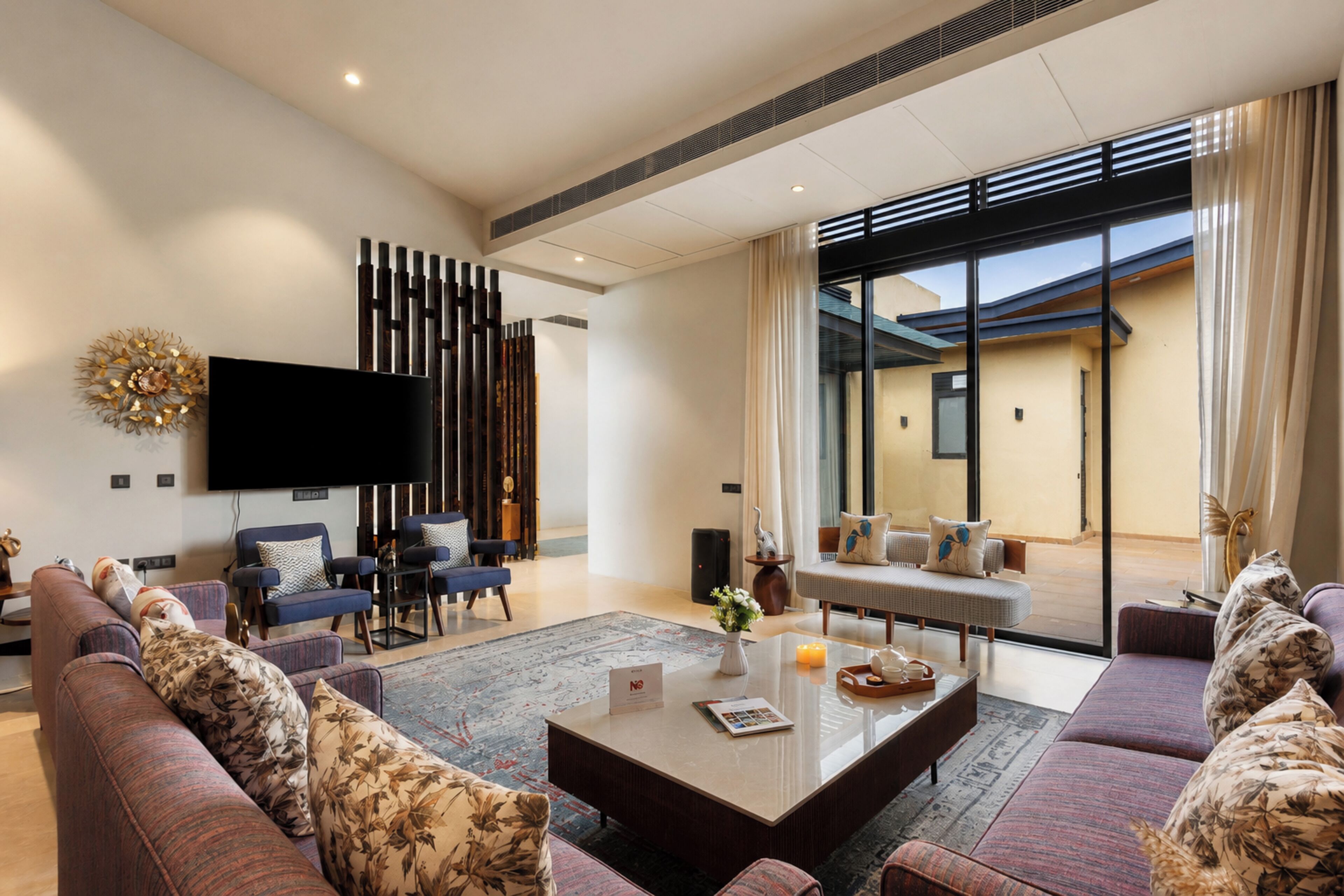 Una sala de estar moderna con un conjunto de sofá, una mesa de centro y un televisor de pantalla plana montado en la pared.
