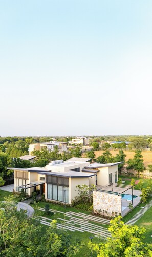 Una zona residencial moderna con varias casas, una piscina y jardines bien cuidados.
