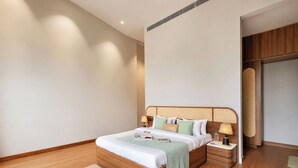 Habitación de hotel moderna con cama de madera, mesitas de noche y una decoración en tonos neutros.