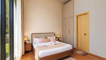A bedroom with a wooden bed, bedside tables, a wardrobe, and a large window.