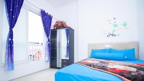 Een slaapkamer met een bed, een kledingkast, een raam met gordijnen en een decoratie aan de wand.