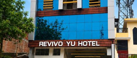 A hotel with a prominent sign, a modern facade, and a gated entrance.