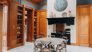 Una cocina con armarios de madera, una mesa redonda de comedor y un plato decorativo grande en la pared.