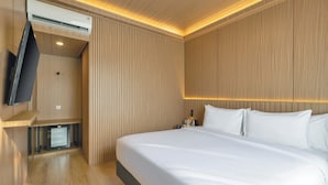 Une chambre d’hôtel équipée d’un lit, d’un téléviseur à écran plat, d’un mini-réfrigérateur et d’un chauffage intégré.