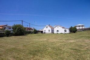 Ein Wohngebiet mit Häusern, einer grünen Wiese und blauem Himmel.