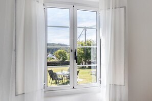 Ein Zimmer mit einer Schiebetür und Zugang zu einem Außenbereich mit Tisch und Stühlen.