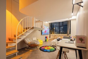 Een modern interieur met een wenteltrap, een flatscreen televisie, een bureau met een laptop en een stadszicht door grote ramen.