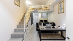 A modern interior with a staircase, a dining area, and a workspace. - ShanghaiHills&SunflowerUltraHorizonHotel (Shanghai)