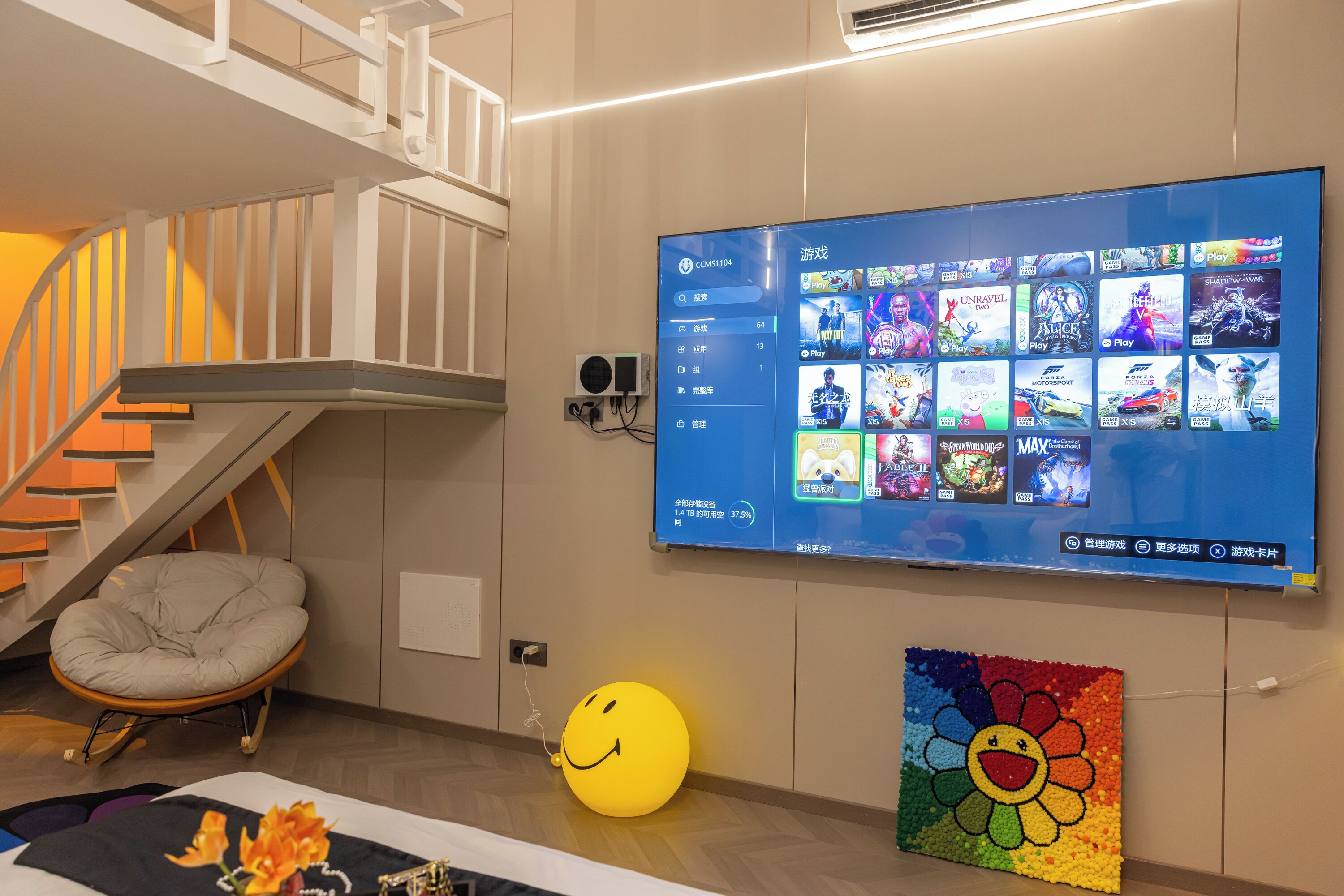 A modern living room with a flat-screen TV mounted on the wall displaying a game library.