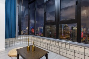 A modern interior with a view of a cityscape through large windows. - ShanghaiHills&SunflowerUltraHorizonHotel (Shanghai)