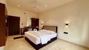 Un dormitorio moderno con una cama grande, ventilador de techo e iluminación en la pared.