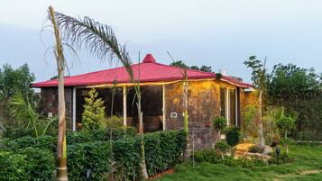 A house with a red roof, surrounded by lush greenery and a well-maintained garden.