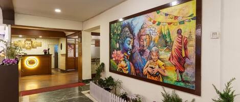 Un área de recepción con un mostrador, un mural grande y una cerca de piquetes blancos.