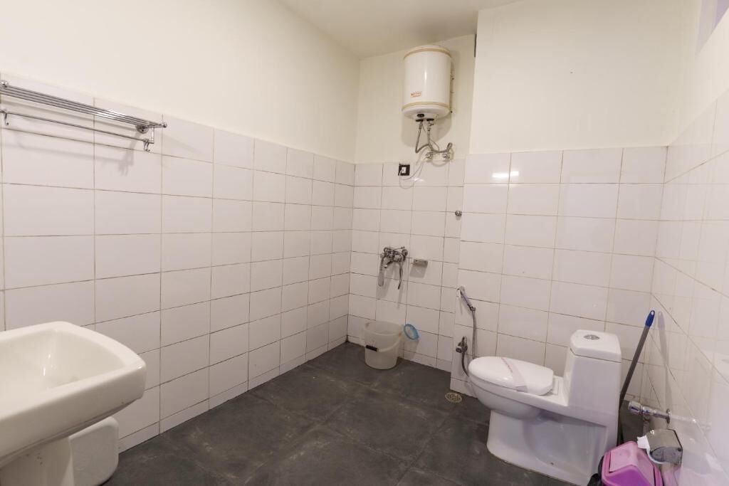 A bathroom with a white sink, toilet, and shower area.