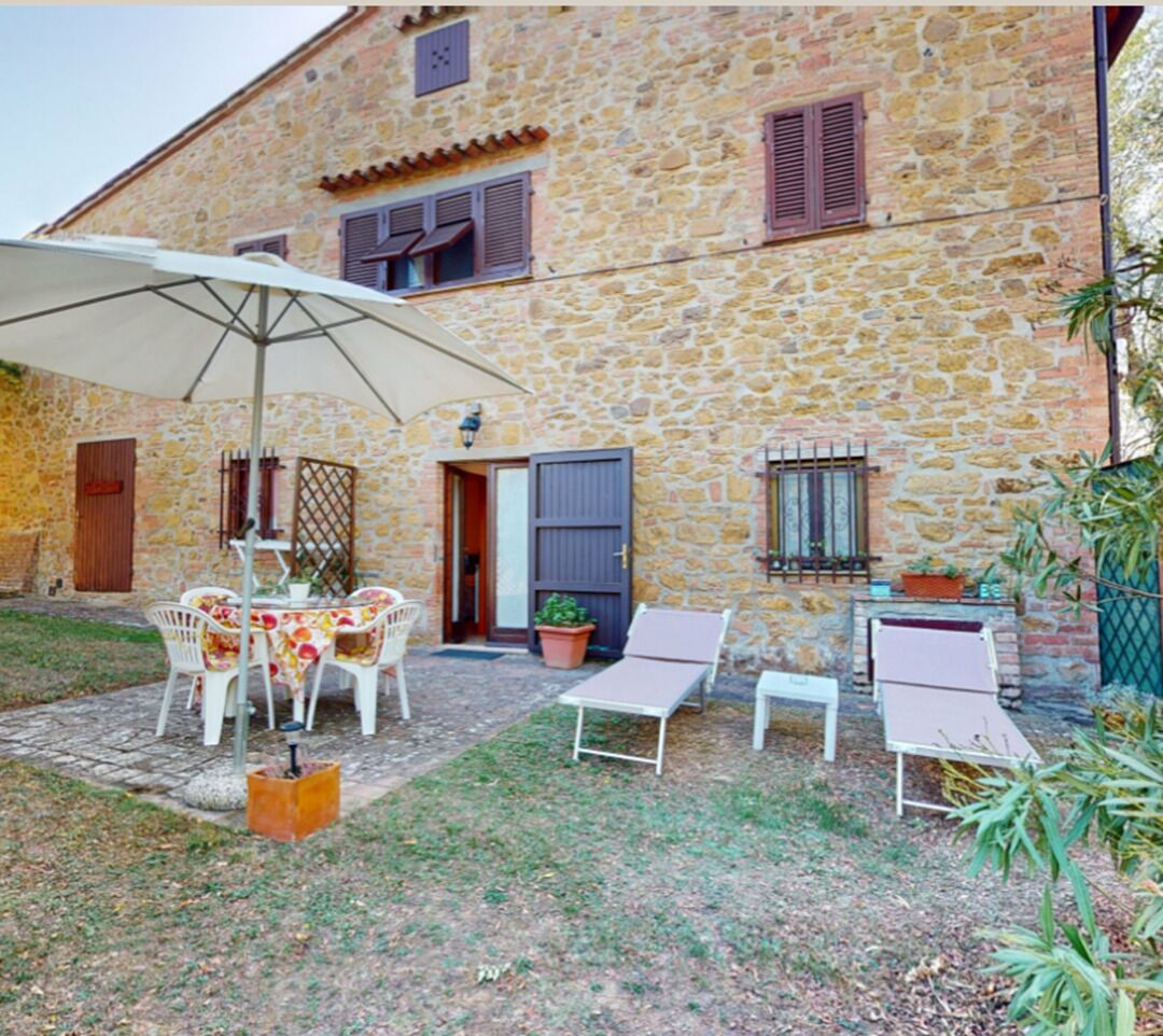 Edificio de piedra con un patio amoblado y una mesa.